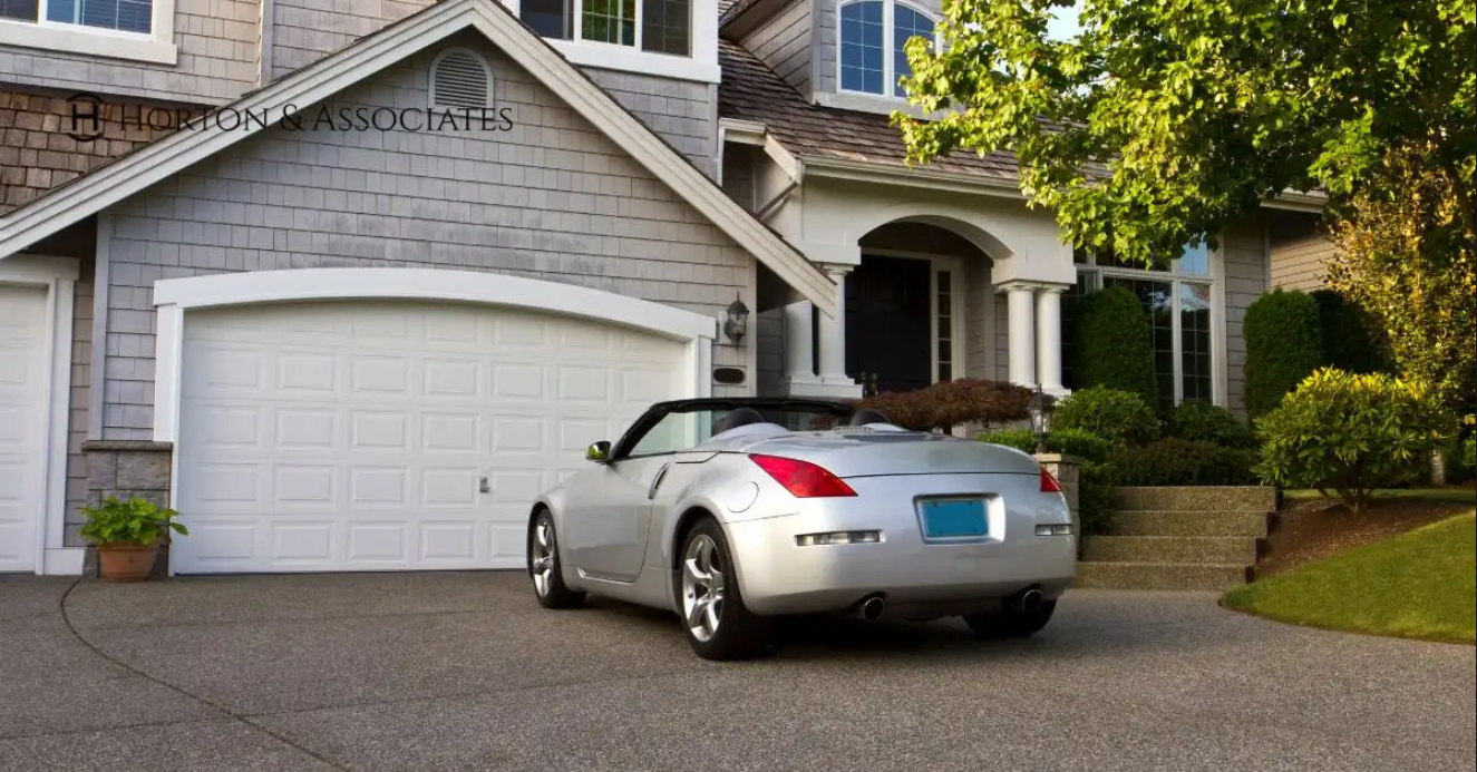 Car parked in front of a house representing home and auto insurance coverage