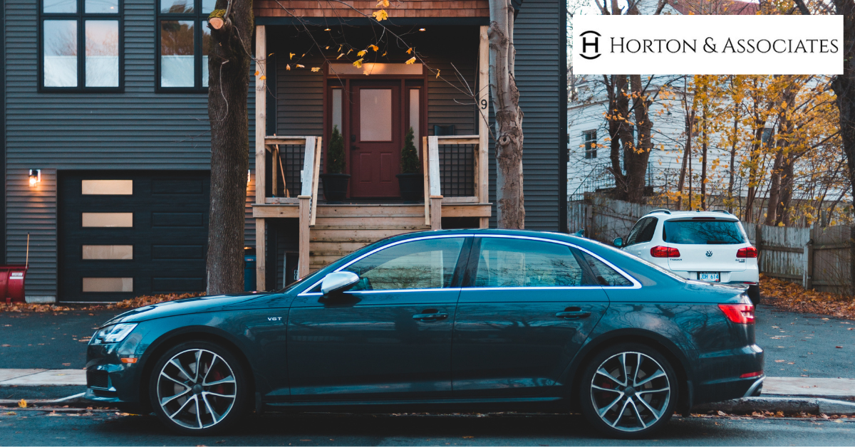 Car parked in front of a residential home representing home and auto insurance coverage